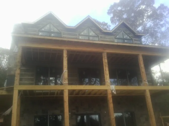 Dormers and porch framing on a large log home under construction — Roof Coating work by our crew in North Bergen