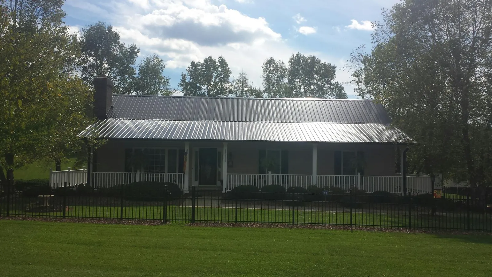 Gray metal roof on a brick ranch with a full width front porch — Gutter Guard Installation work by our crew in North Bergen